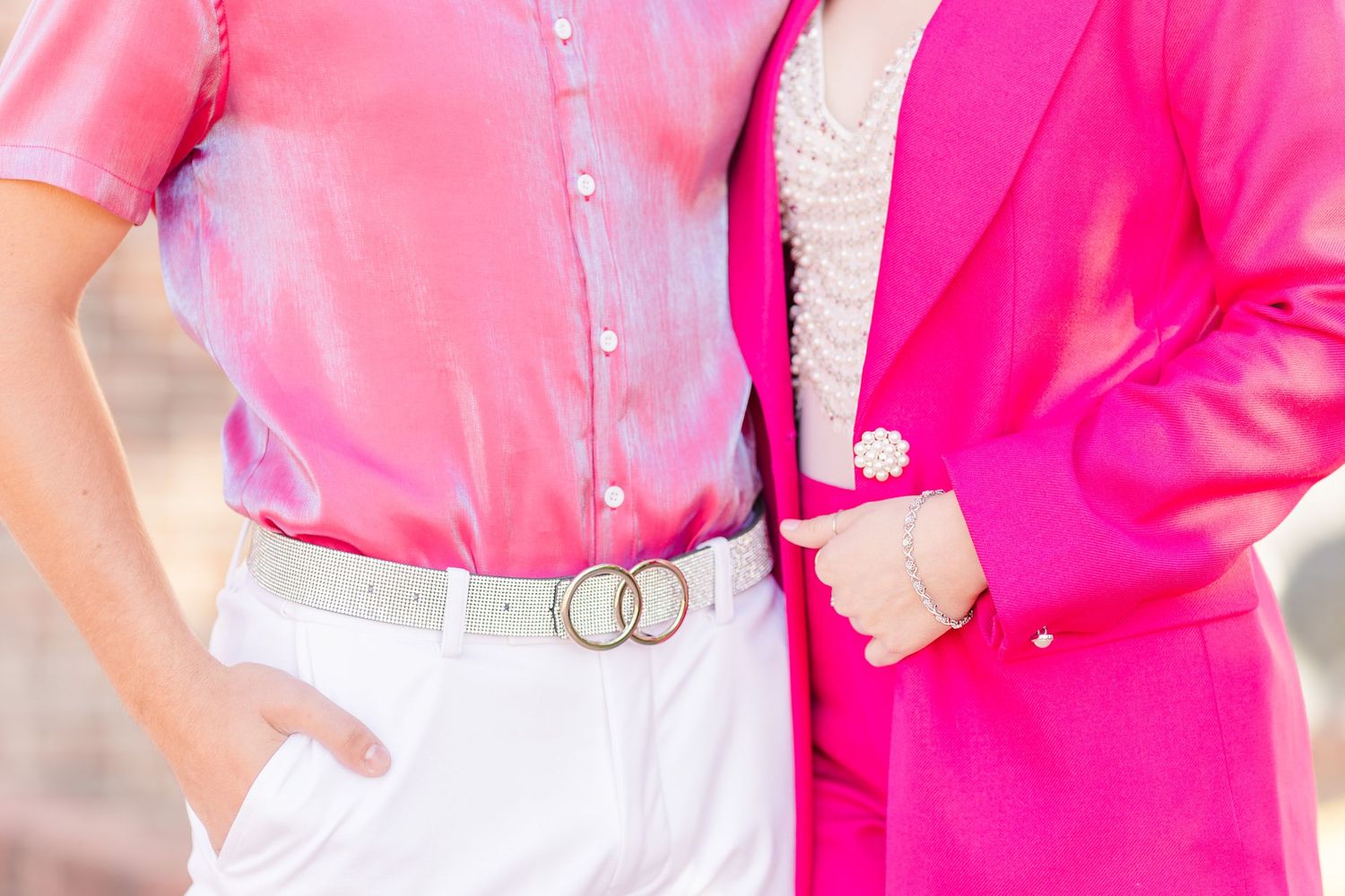 Close-up fashion detail of pink and white spring outfits with double ring belt and blazer.