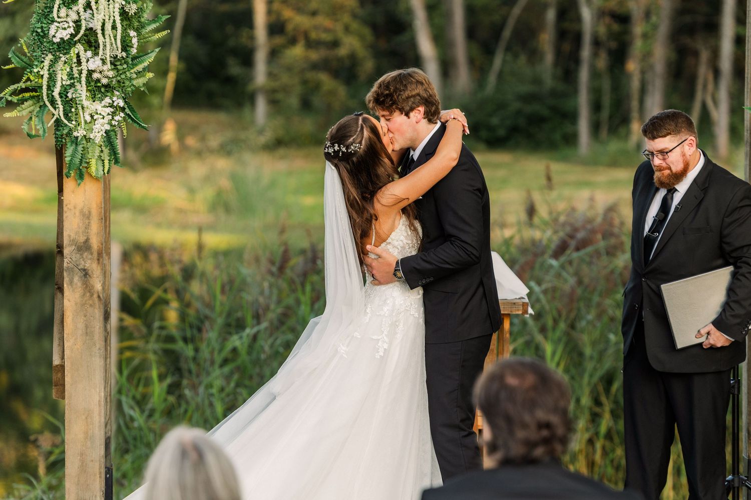 Wedding ceremony moments captured under wooden pergola during golden hour.