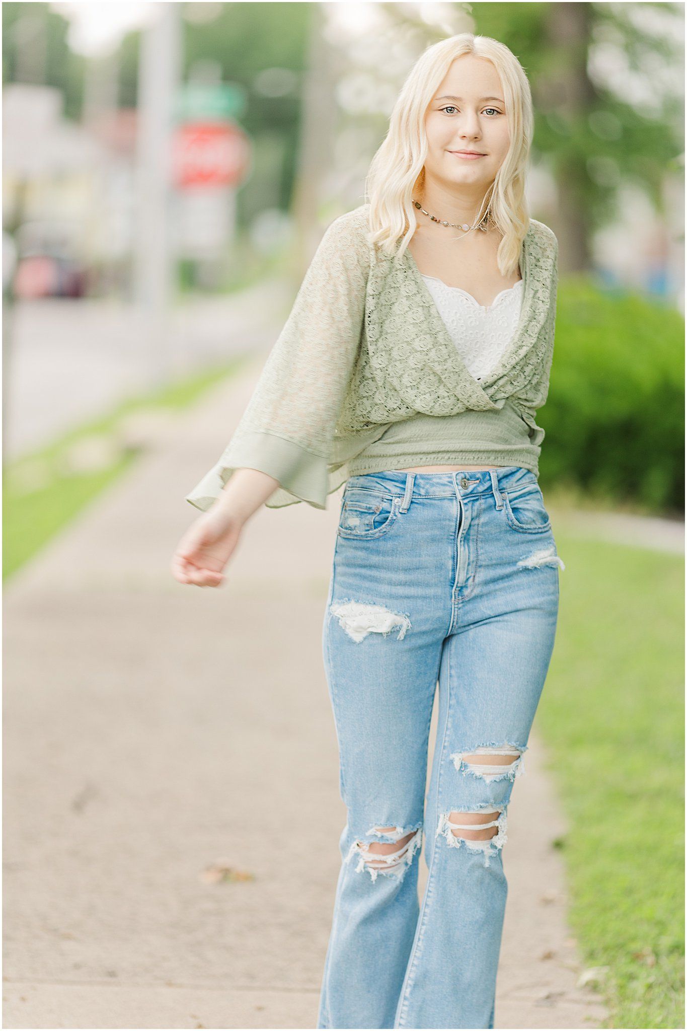 senior girl strolls down sidewalk