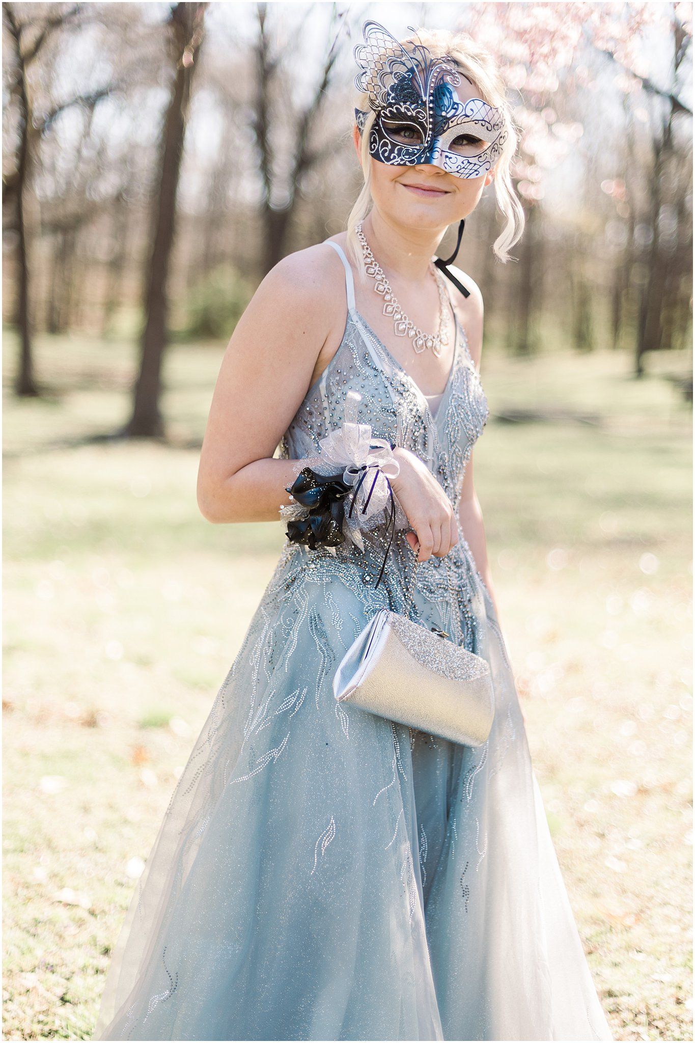 Formal attire with blue mask and sparkly dress holding small purse.