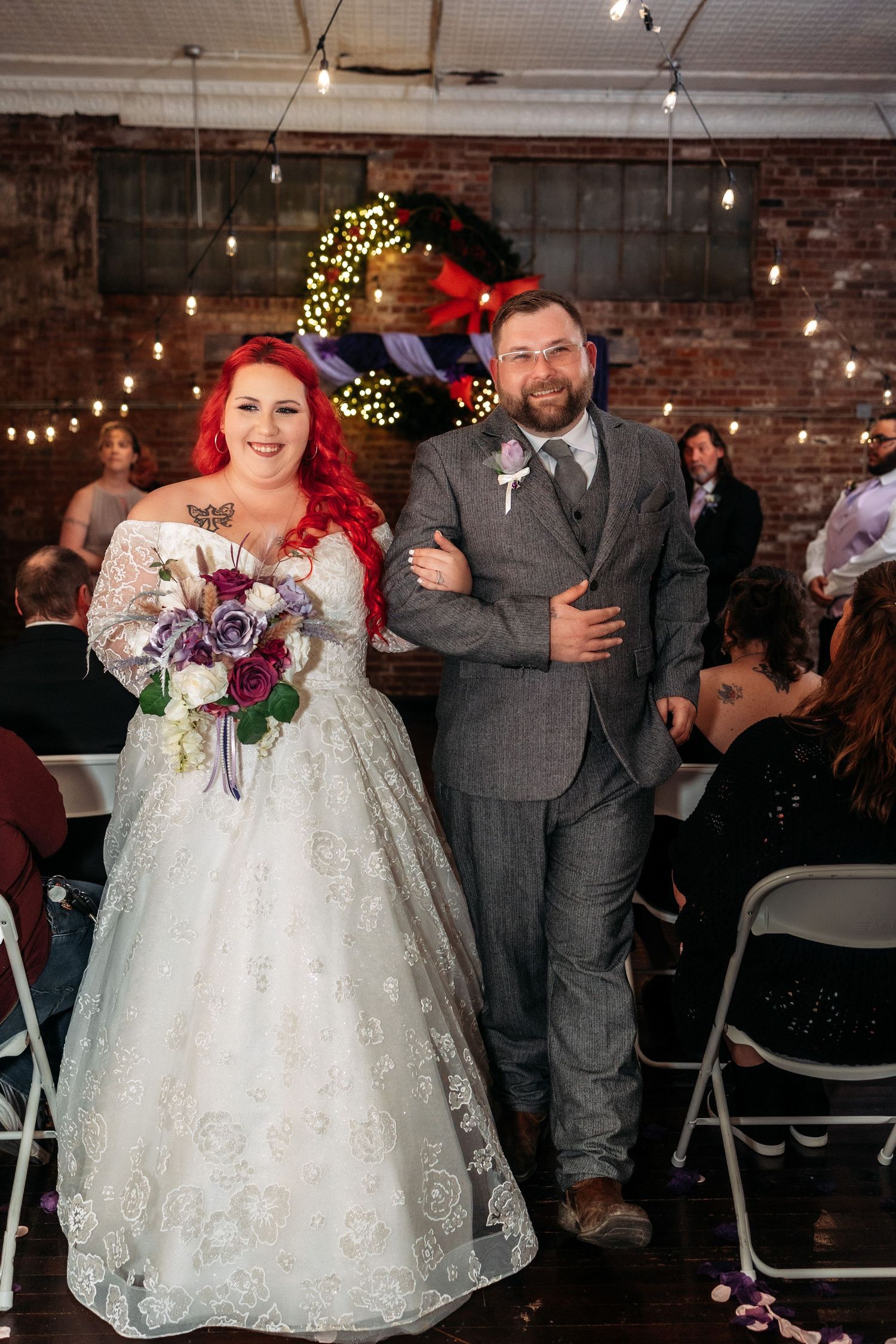 Wedding celebration in an industrial-style venue with exposed brick walls and string lights.
