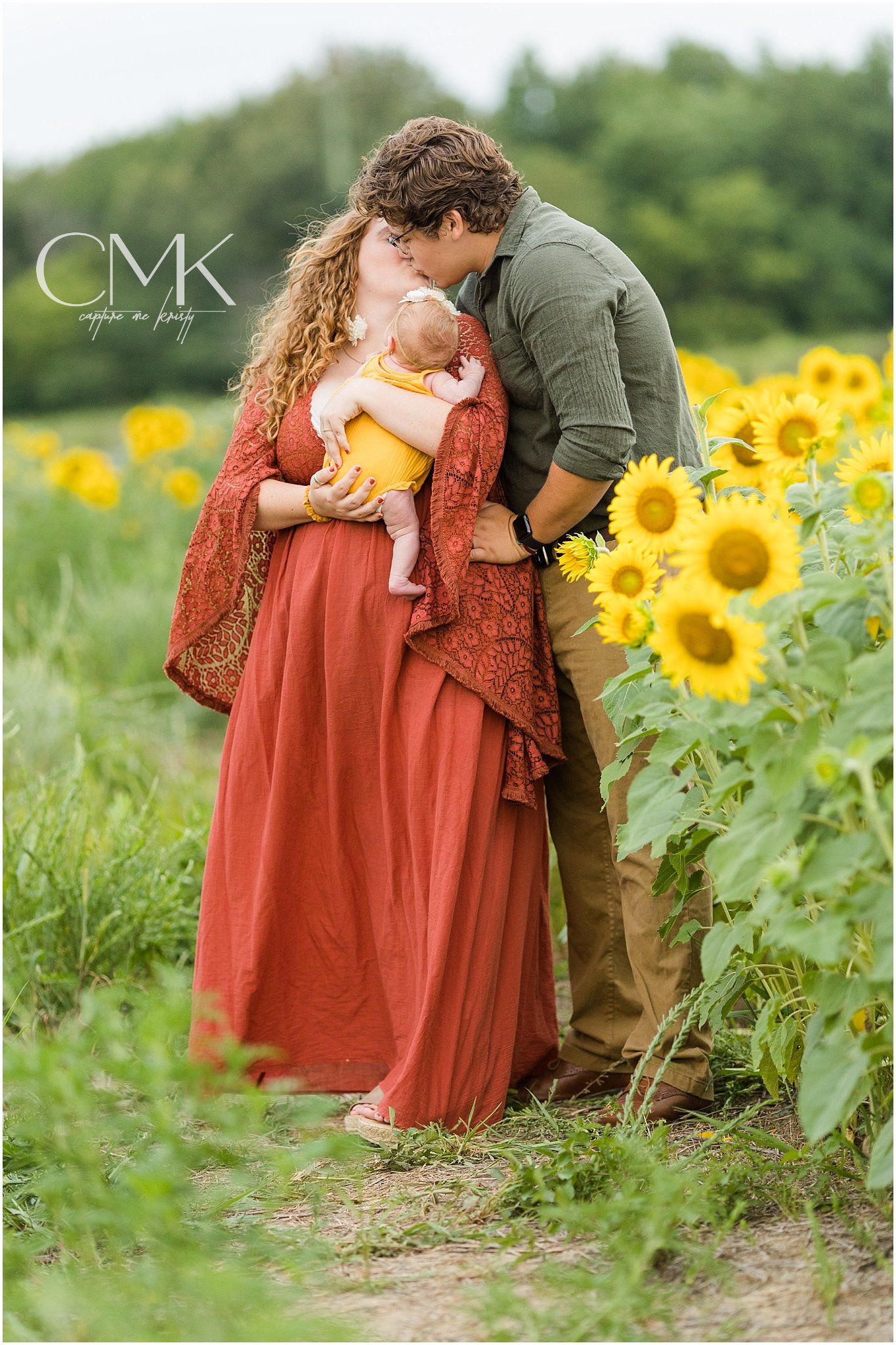 Intimate family portrait among tall sunflowers during golden hour photography session.