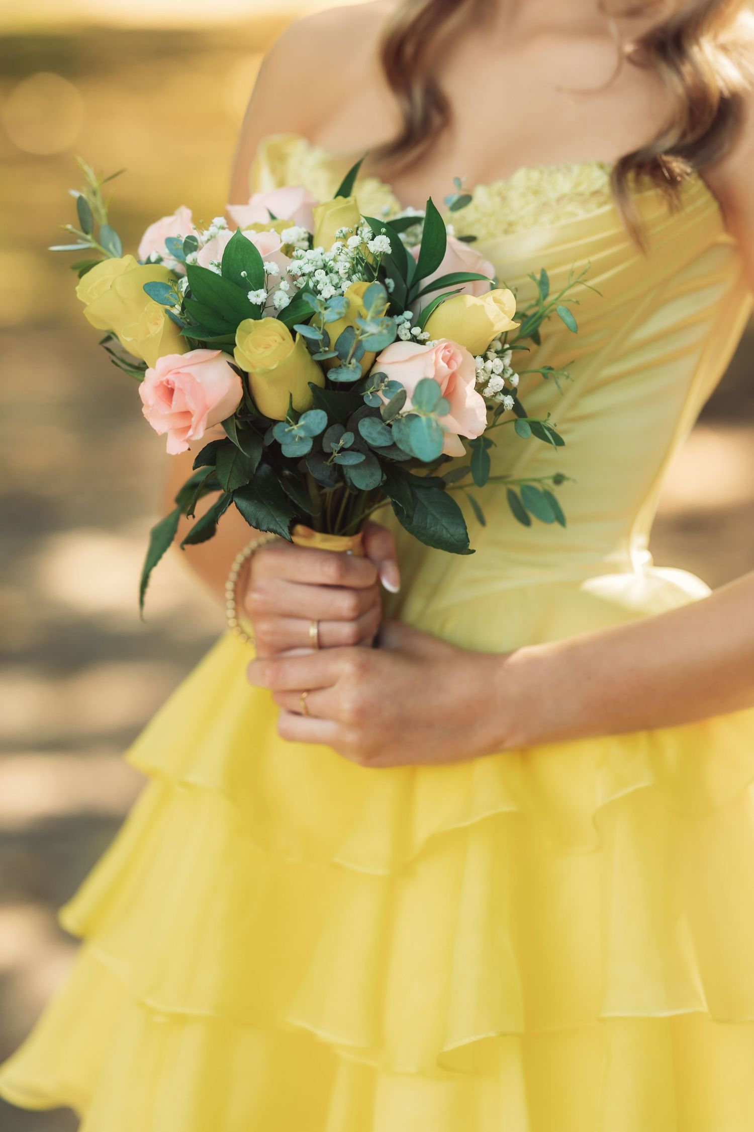 Yellow dress with floral bouquets featuring pink roses and greenery.