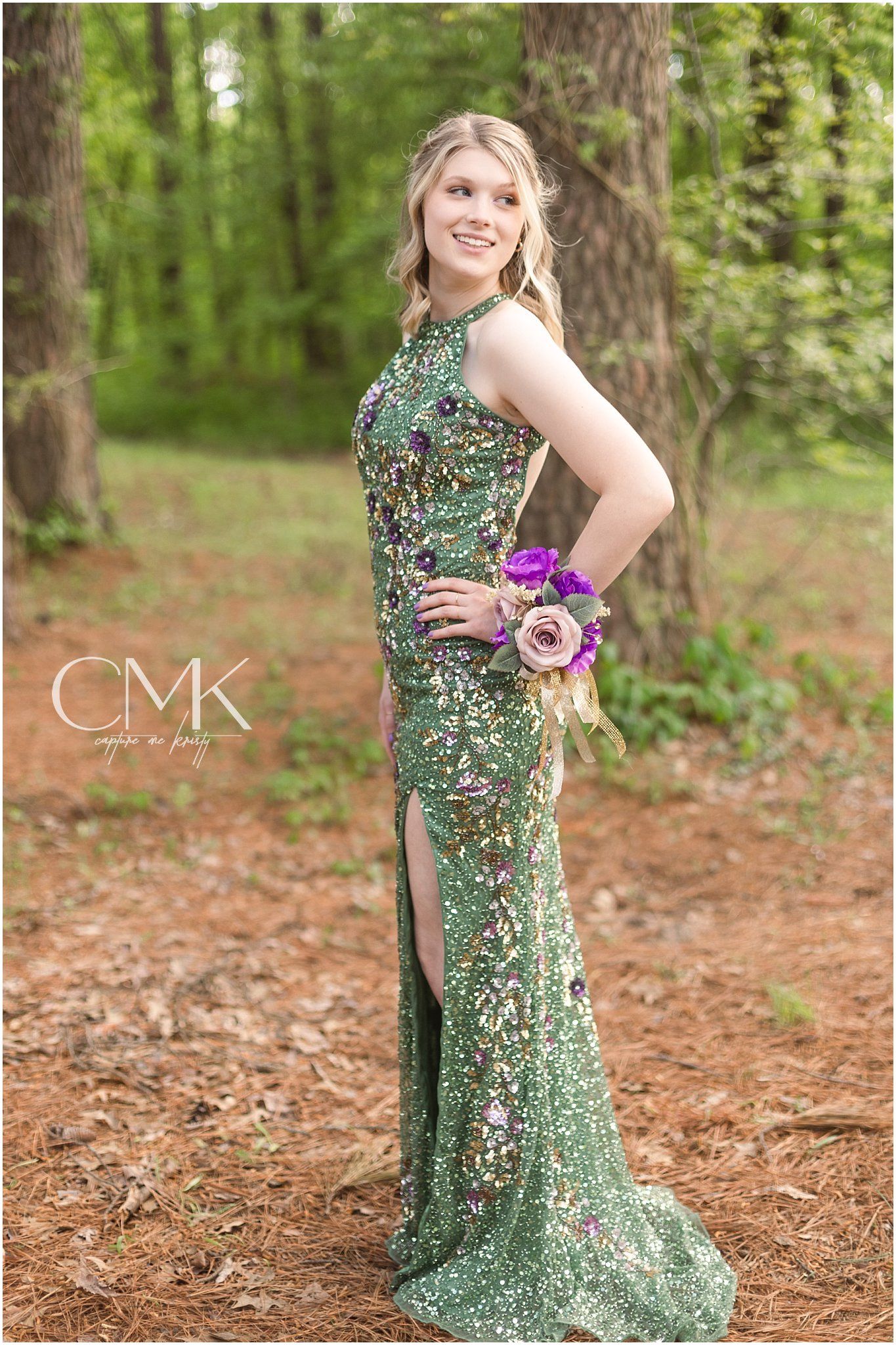 A stunning emerald sequined formal dress shimmers in a forest setting.