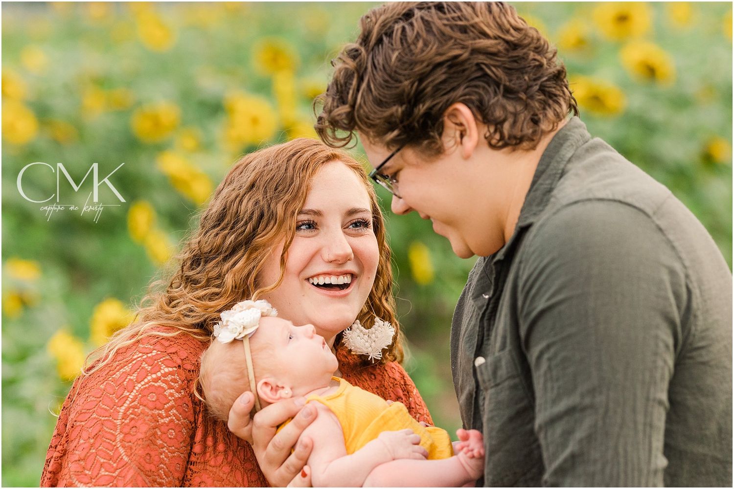 Joyful family moment captured in sunlit field with yellow flowers.
