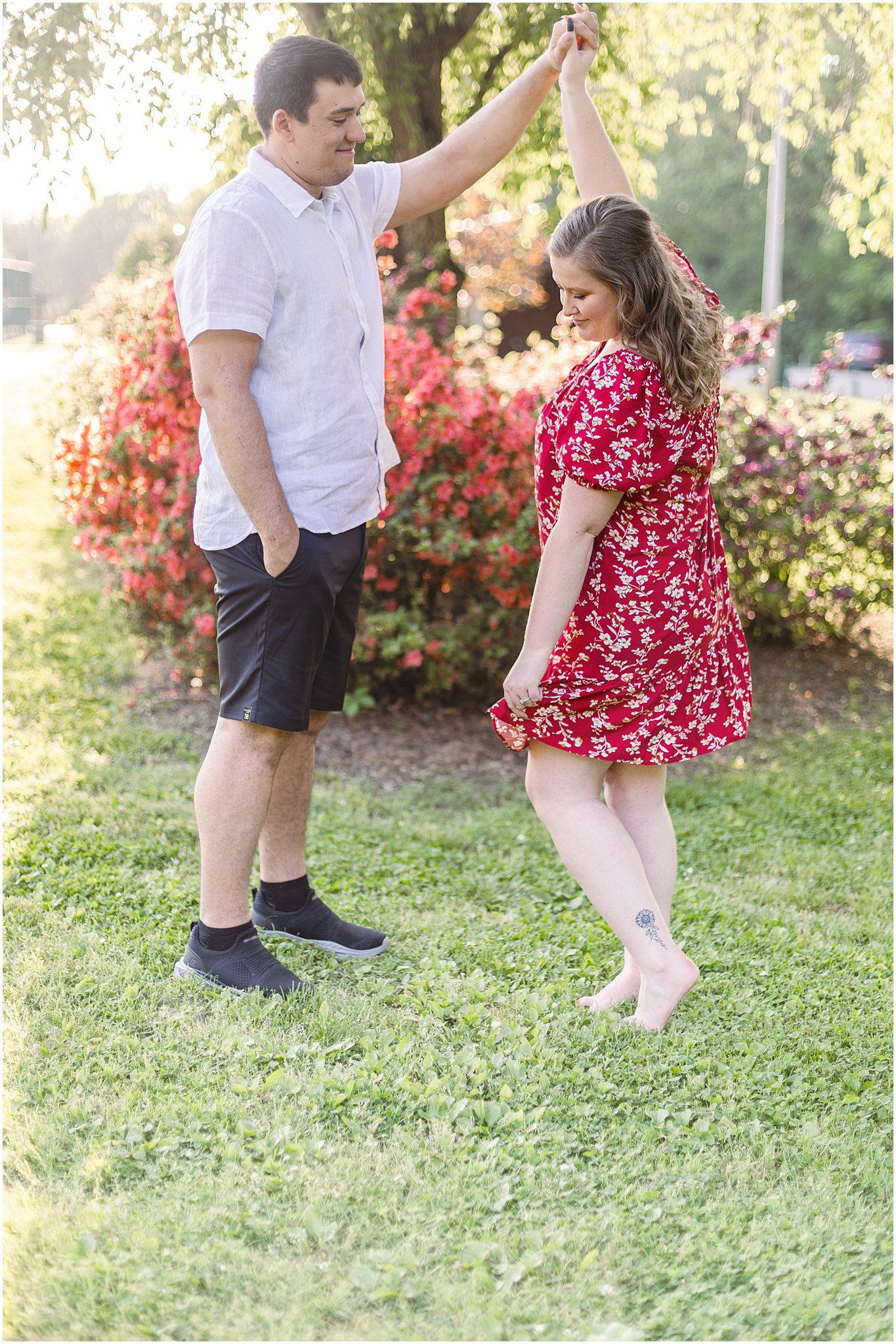 Playful dancing moment captured outdoors with couple in casual spring attire.