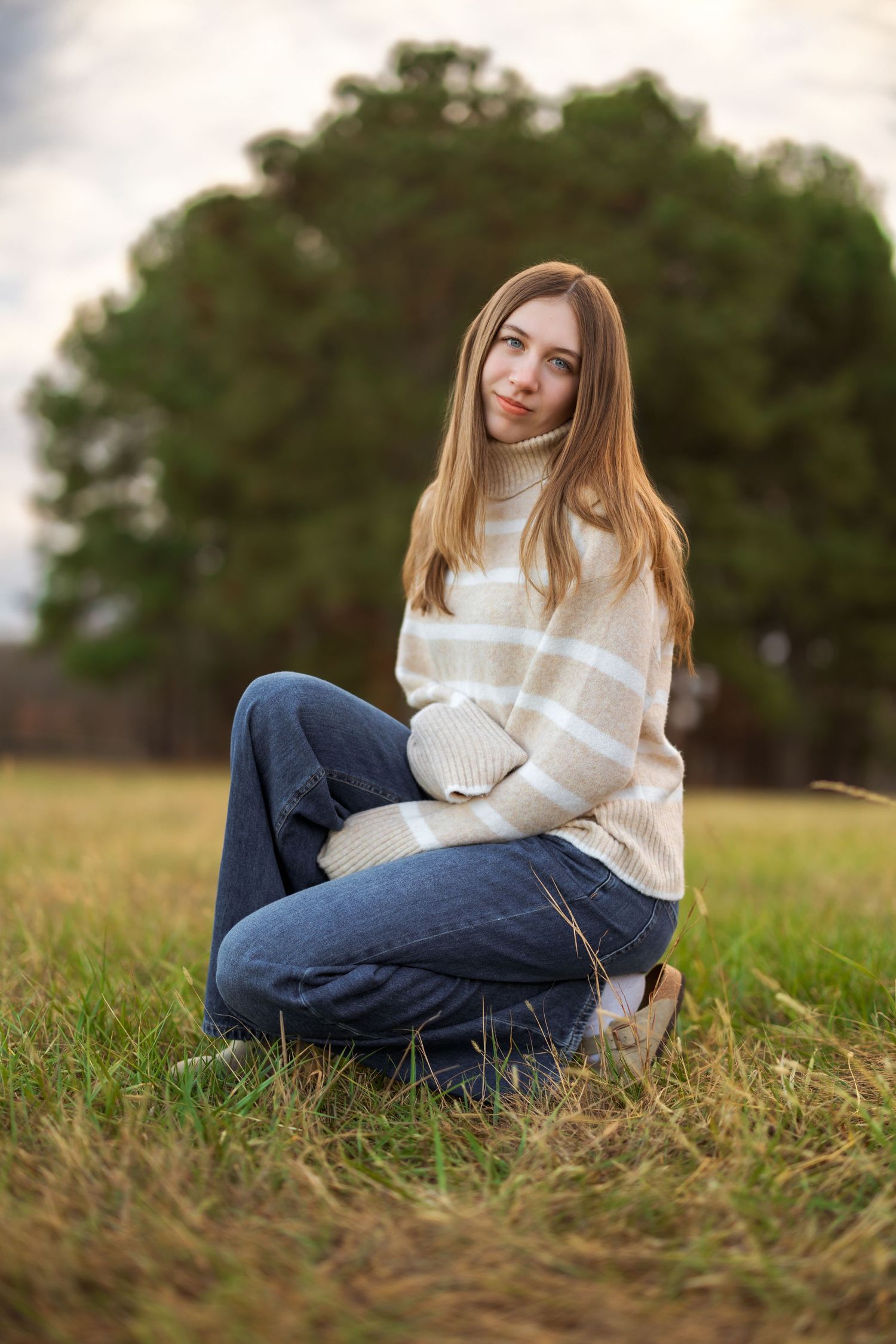 Person in cream sweater relaxing in autumn field.