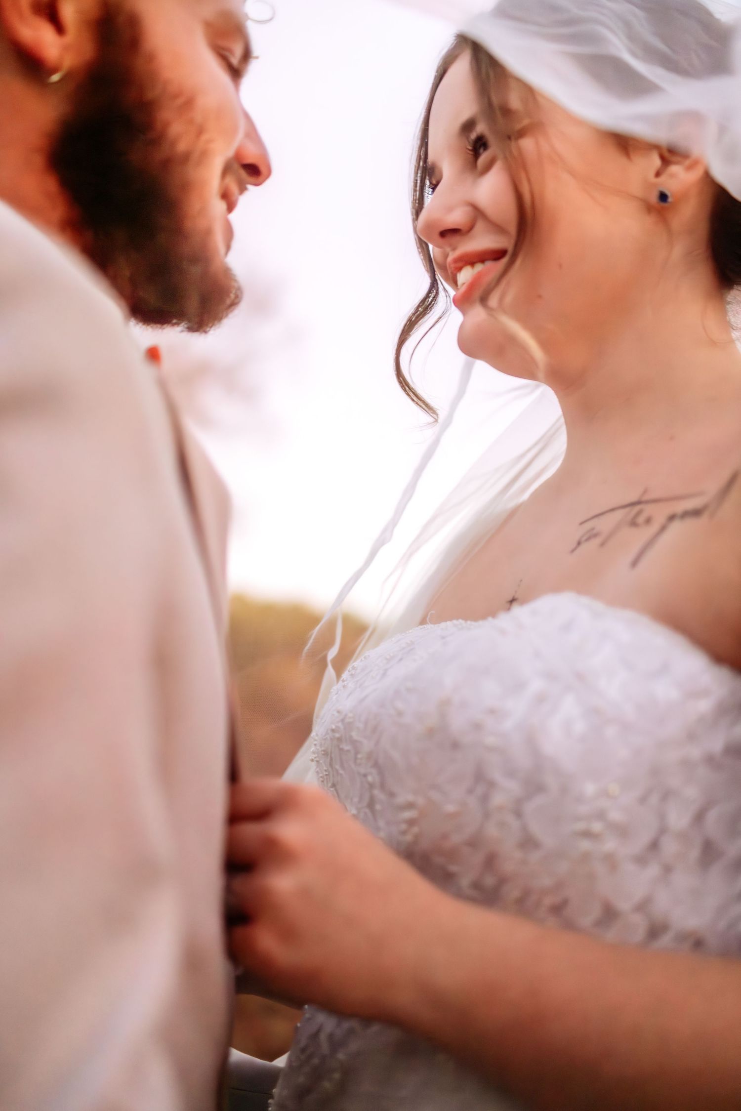 Close-up wedding portrait showing tender moment between couple in cream and white attire.