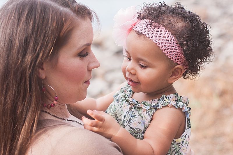 Intimate portrait of parent and baby sharing a moment together outdoors.