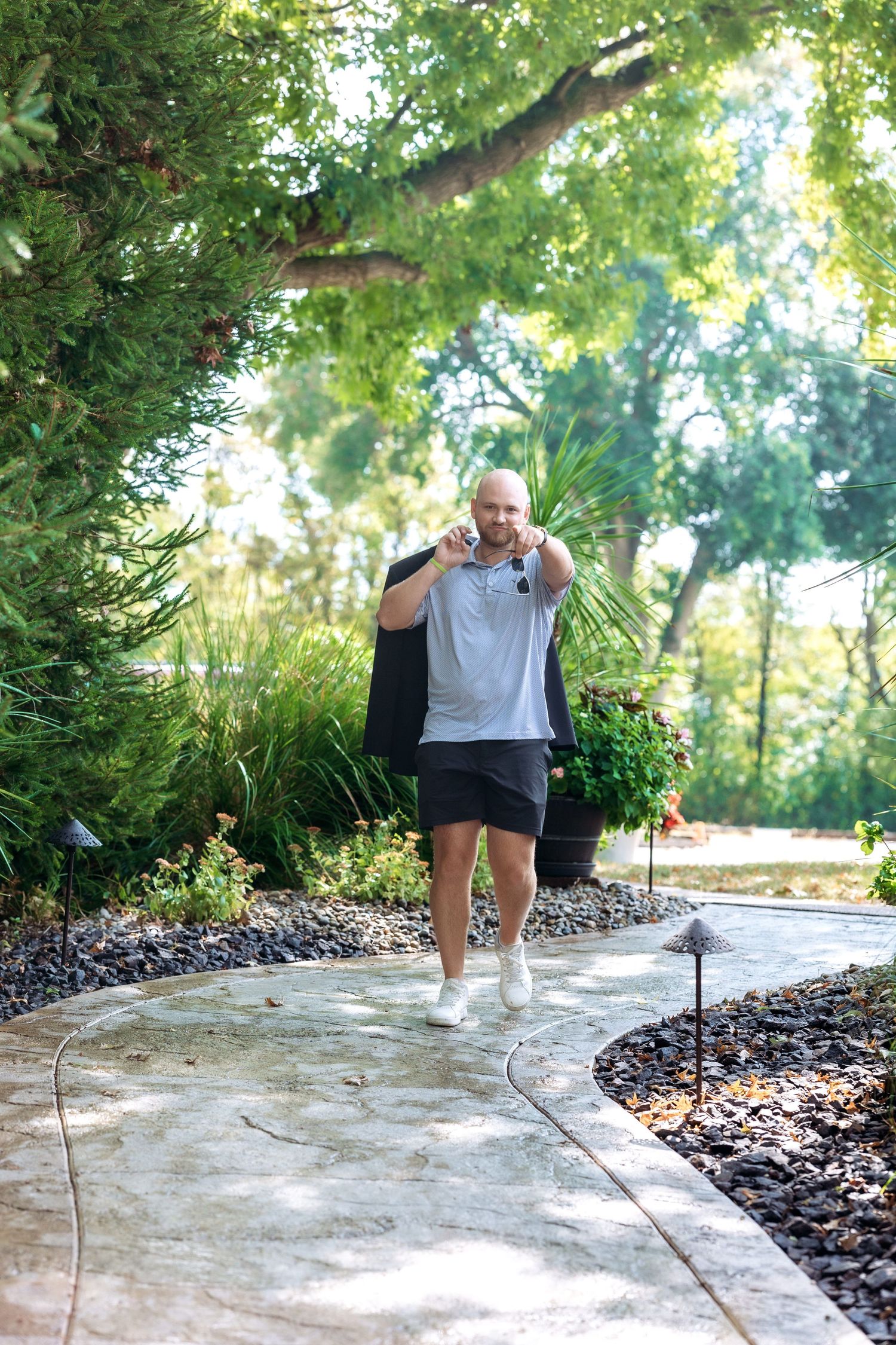 Person performing dance steps on a curved concrete path with landscaping.