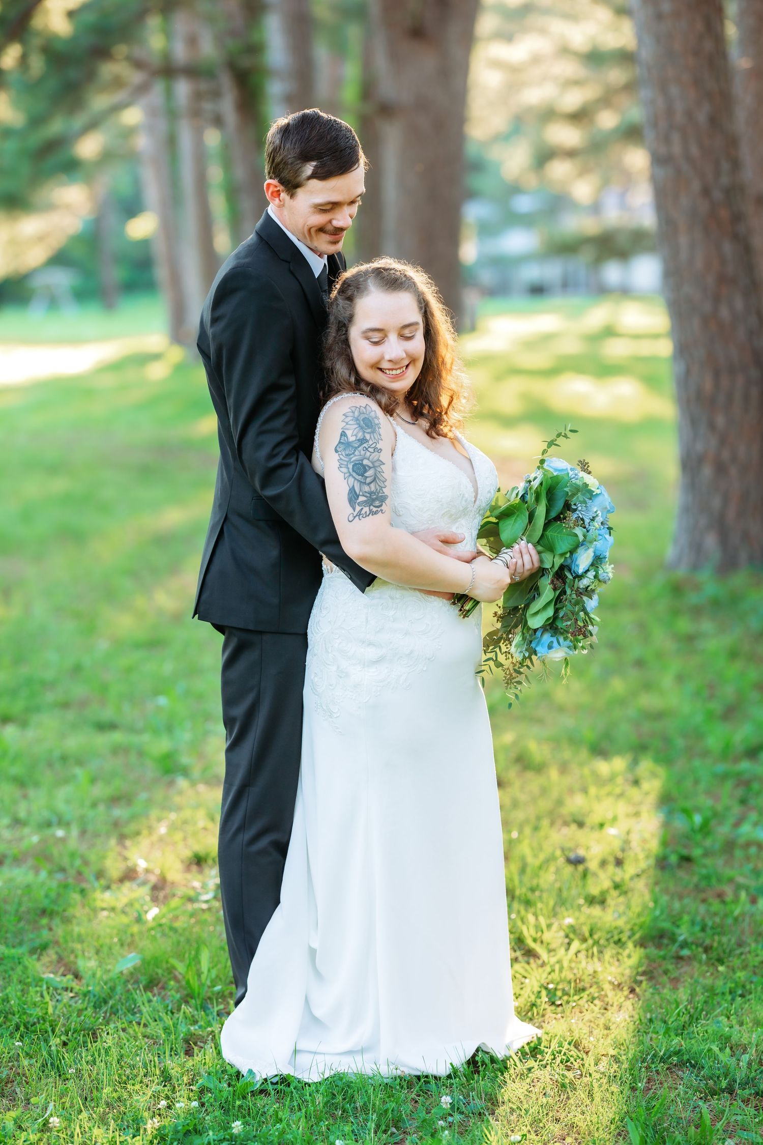 Couple shares intimate moment during outdoor wedding photoshoot in wooded setting.