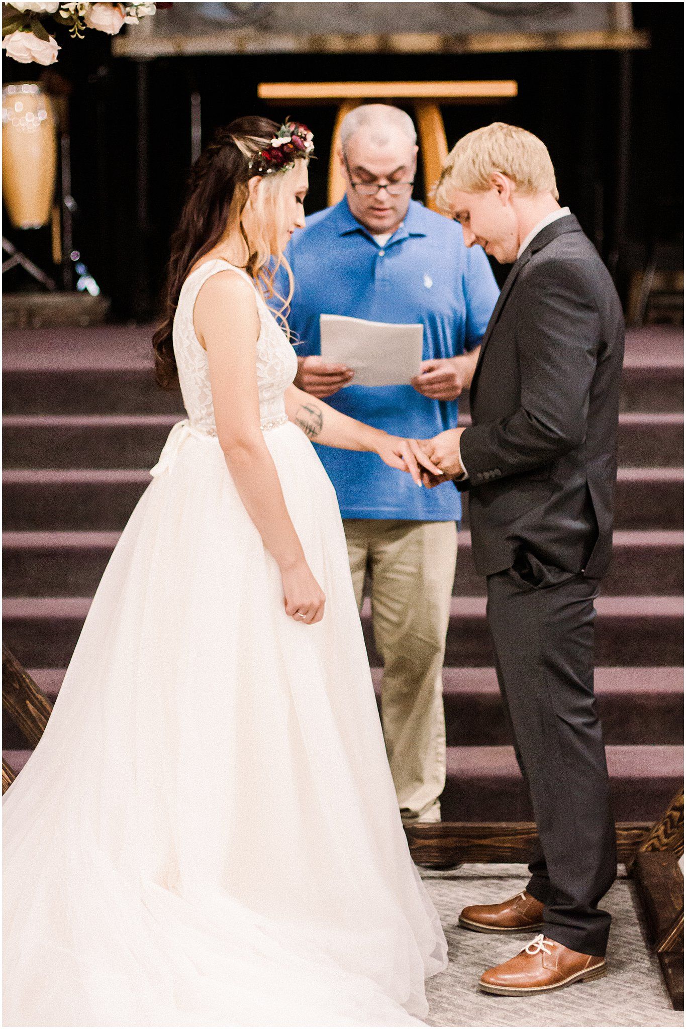 A couple exchanges rings during their wedding ceremony as an officiant guides them through their vows.