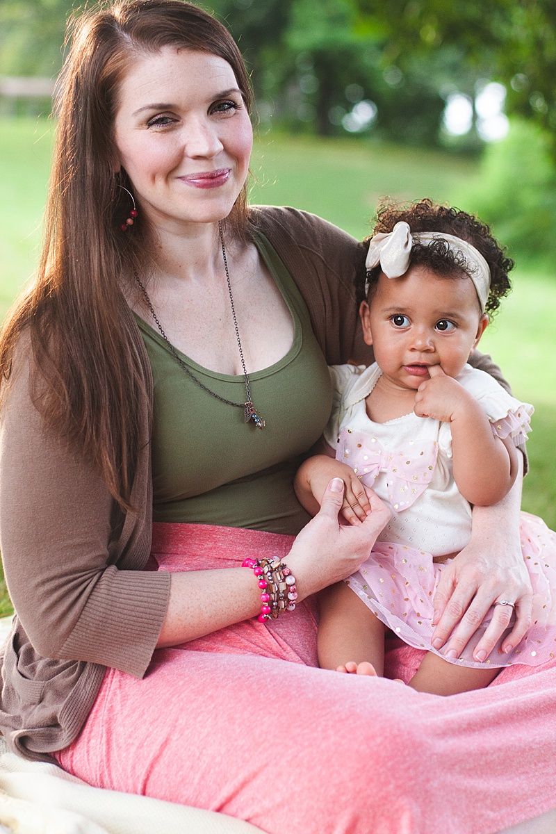 Heartwarming outdoor portrait of parent and baby in matching earth-toned clothing.