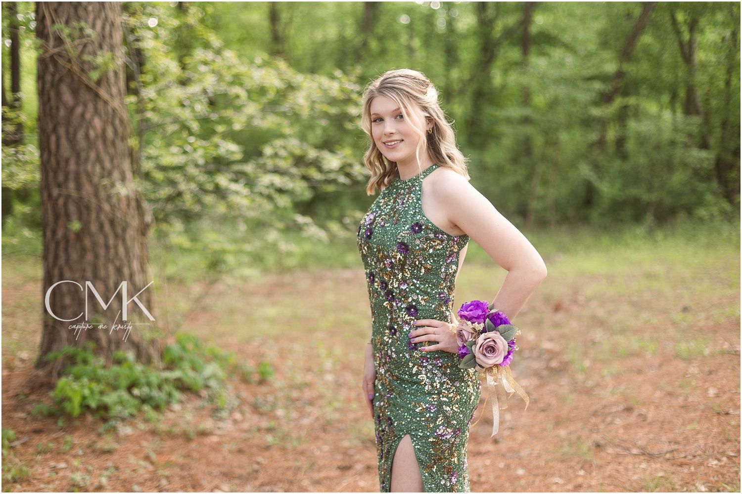 A sequined green formal dress photographed against lush forest greenery.