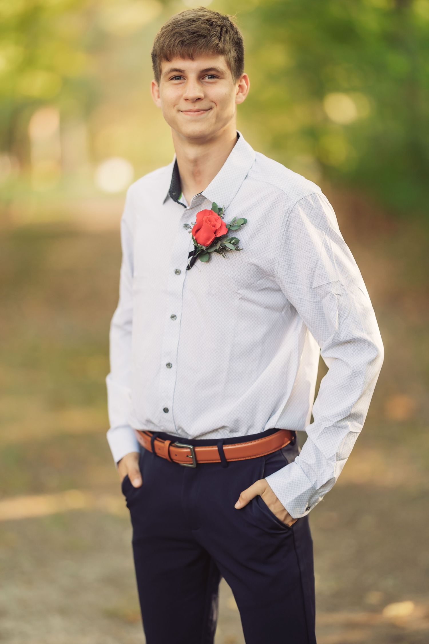 Formal portraits showing white dress shirt, navy pants and red boutonniere details.