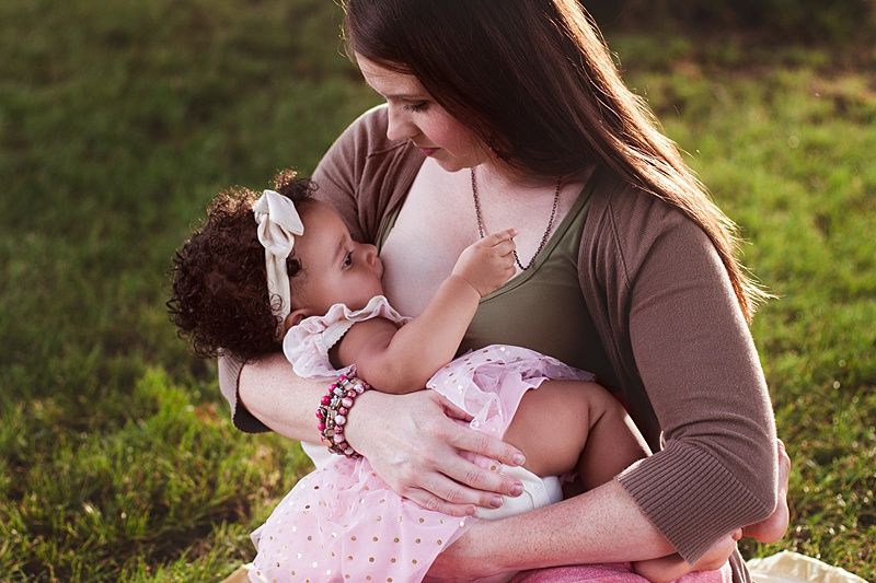 Intimate outdoor nursing session showing gentle maternal bonding.