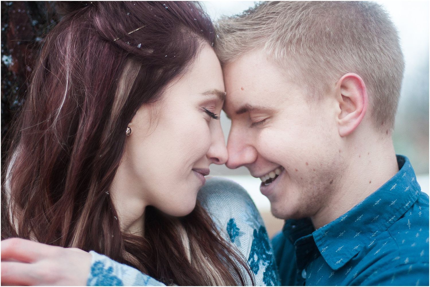 Romantic couple sharing an intimate moment in close-up while wearing blue outfits.