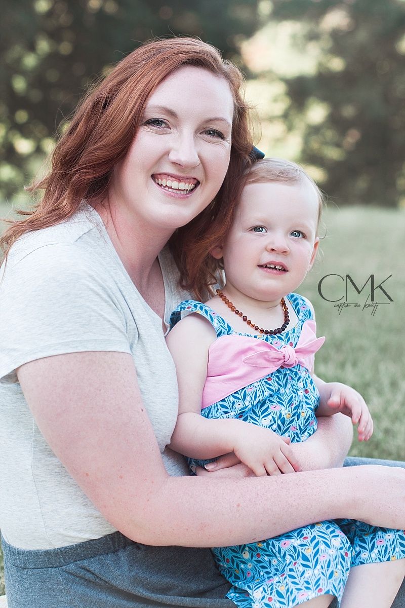 Joyful outdoor portrait showing warm embrace between parent and child in summer garden setting.