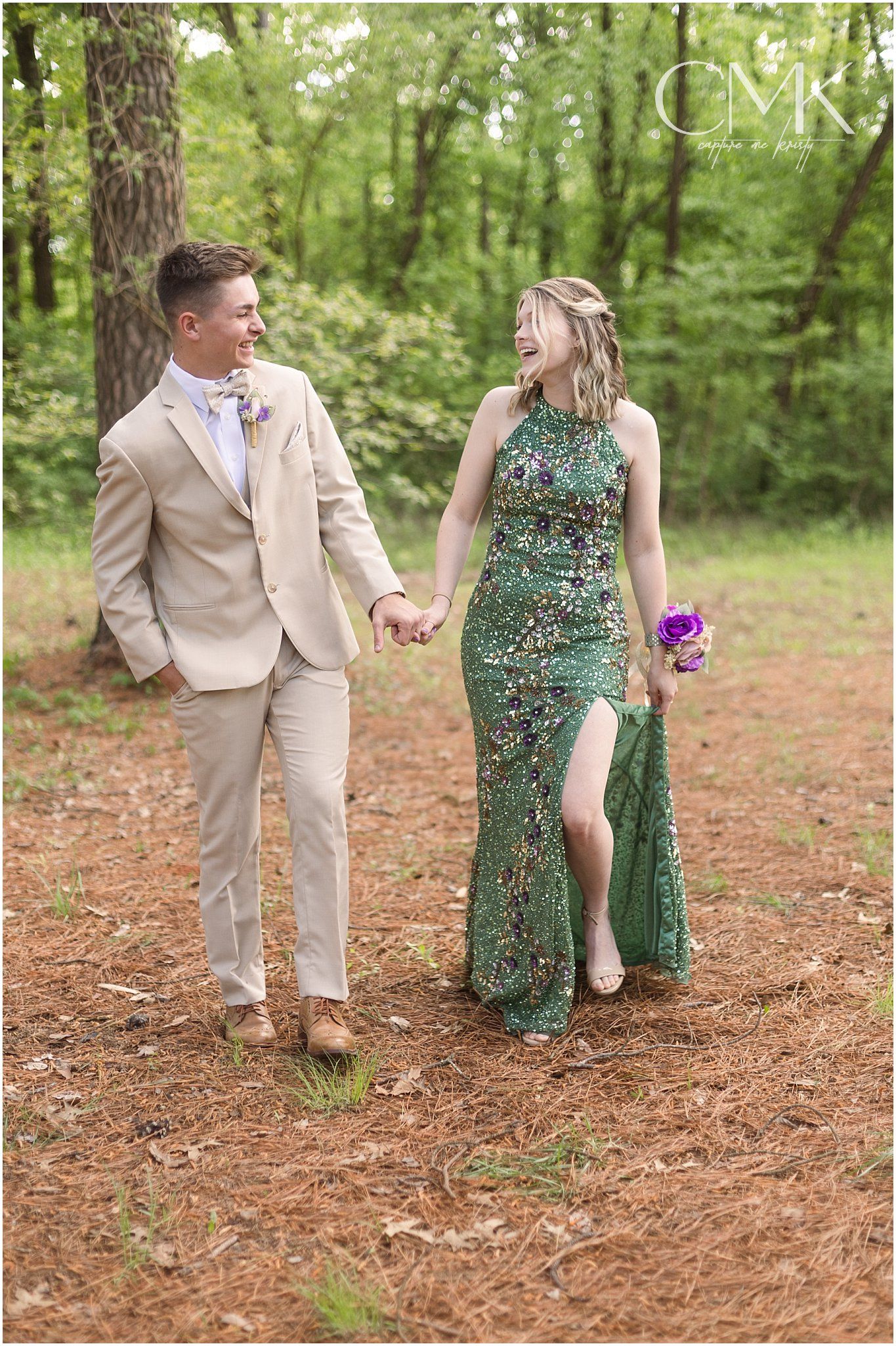 Couple sharing a joyful moment while walking hand in hand through a forest.