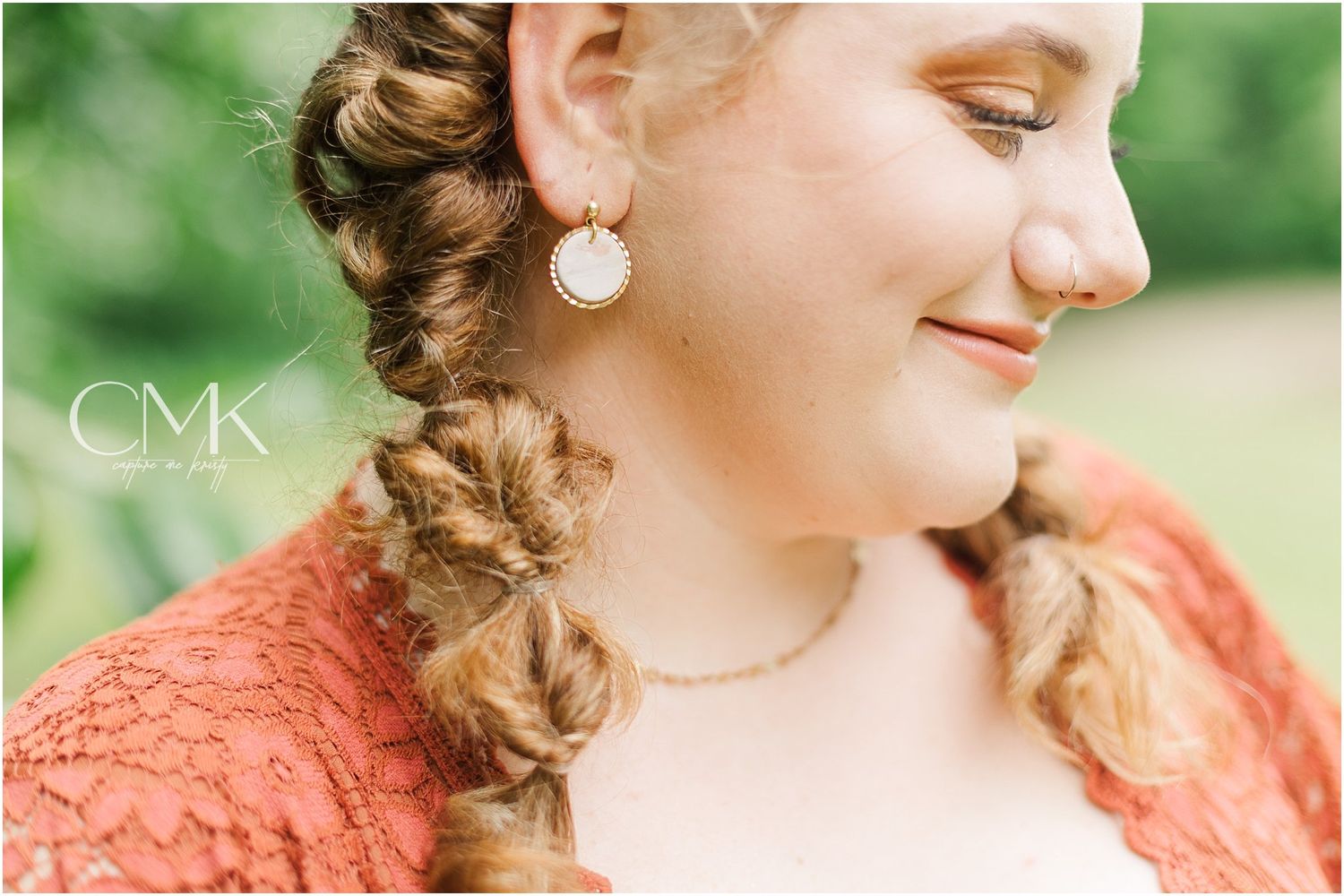 A profile shot showing intricate braided hair styling and pearl earring details.