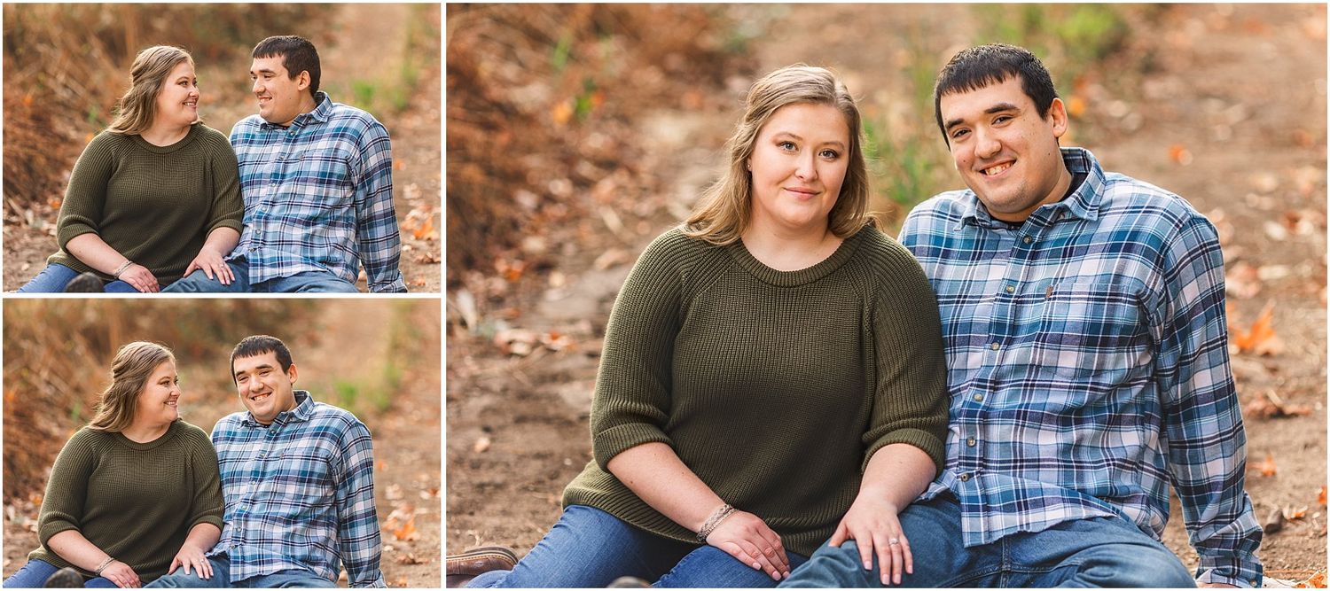 Couple poses for autumn engagement photos on fallen leaves in a rustic outdoor setting.