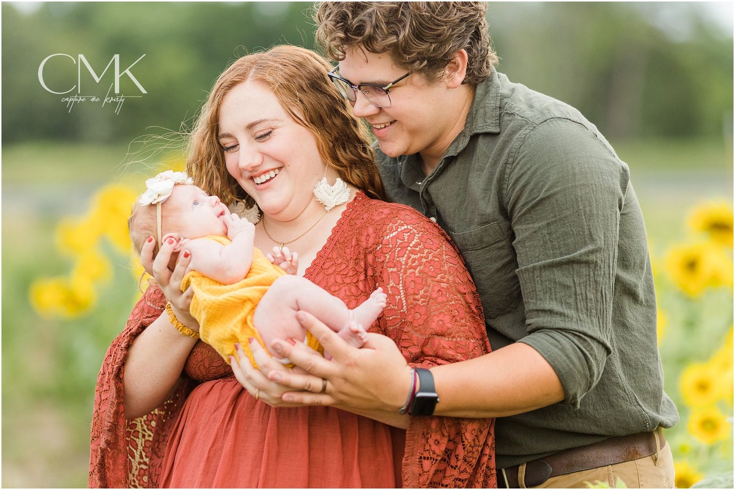 Candid family moment captured in beautiful sunflower field during summer photoshoot.