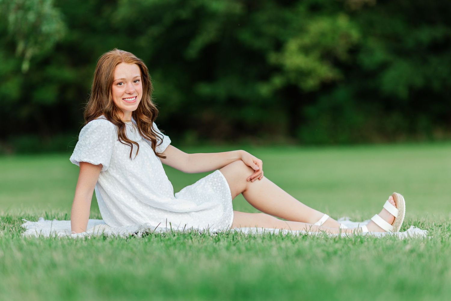 A white summer dress and sandals create an elegant look for this outdoor photo session.