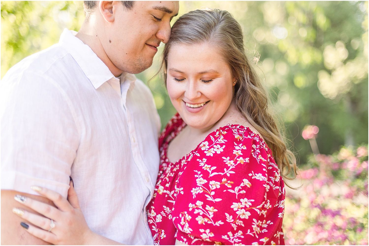 Close-up of couple sharing an intimate moment outdoors in coordinated white and red outfits.