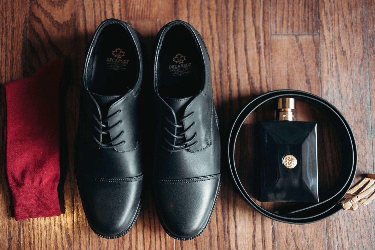 Collection of formal black leather shoes displayed on rustic wooden surface.