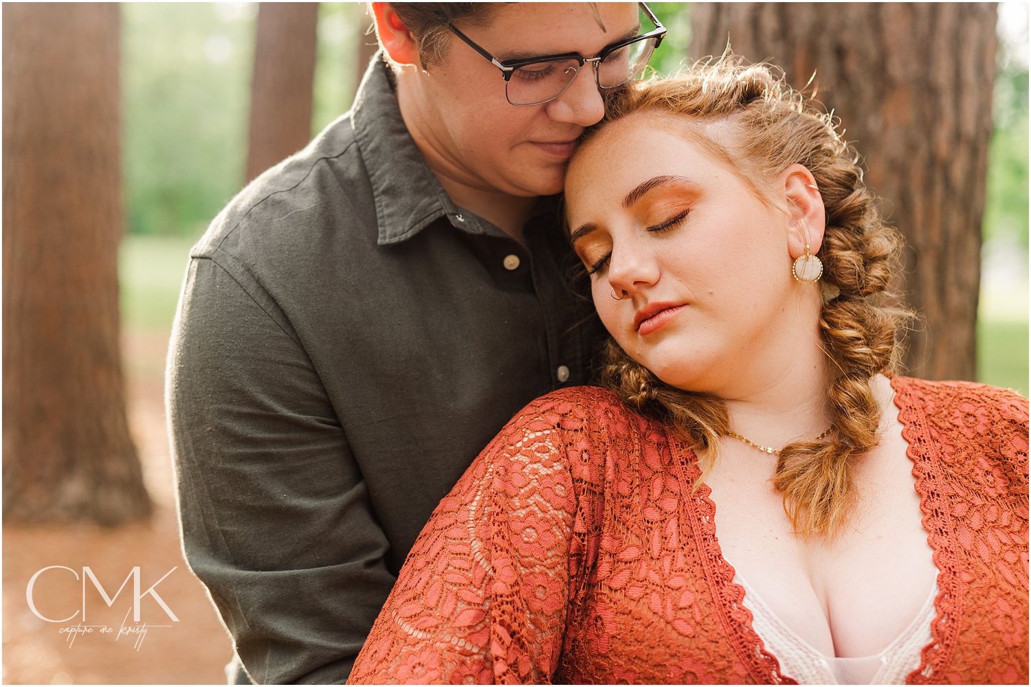 An intimate portrait captured in a forest setting with soft natural lighting.