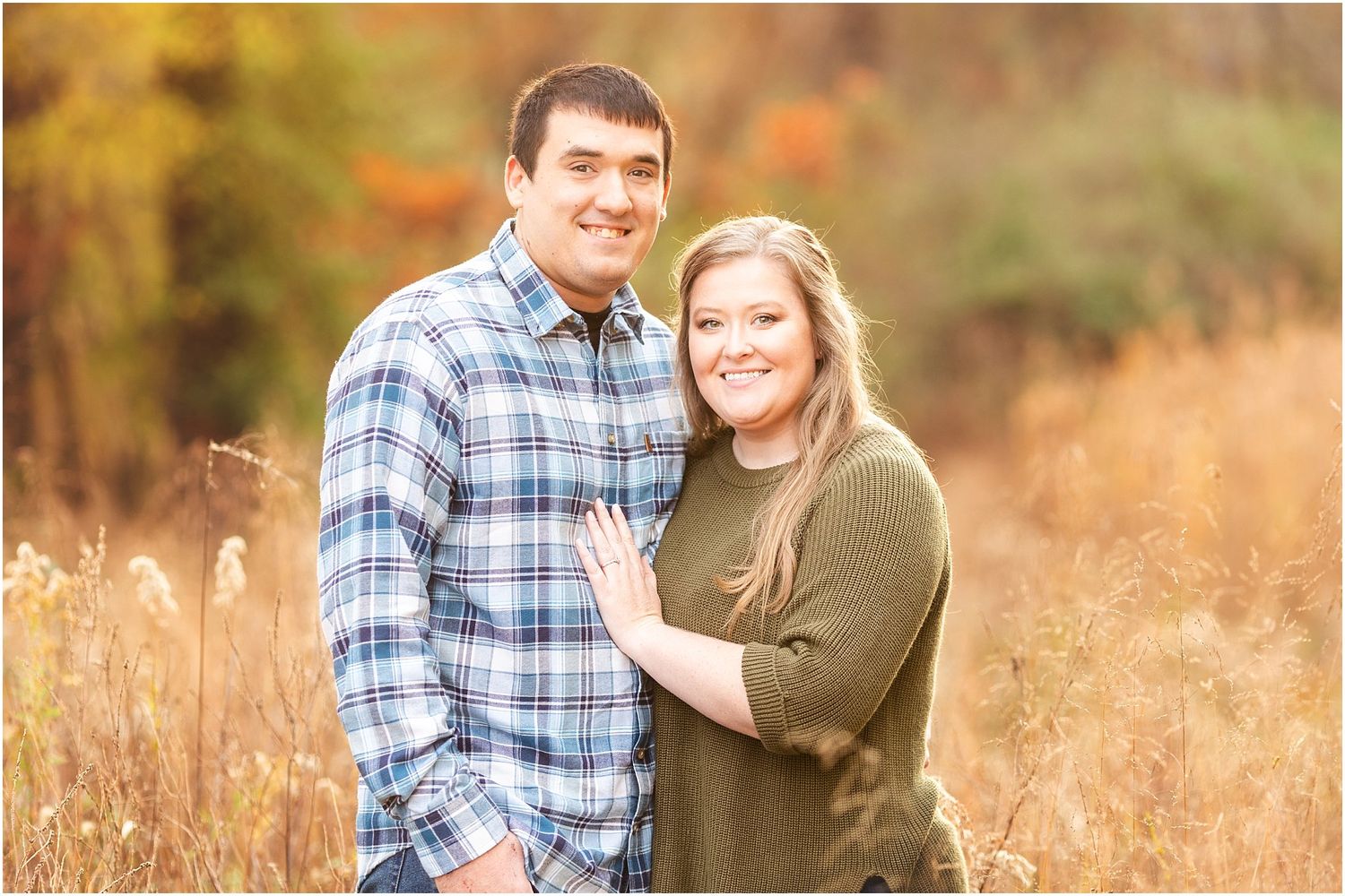 Autumn engagement photo in a golden field during sunset.