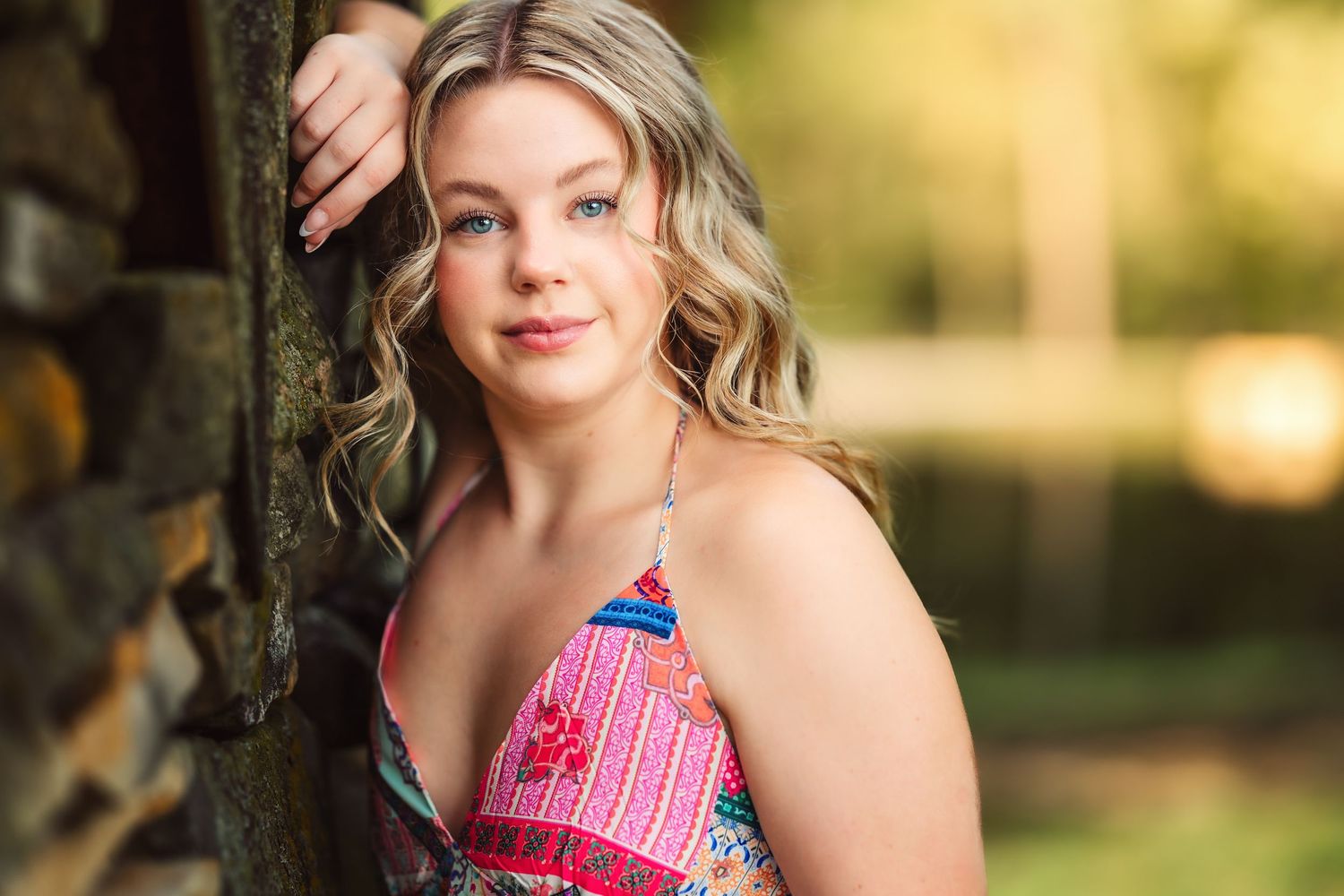 Outdoor portrait with natural lighting and trees in background.