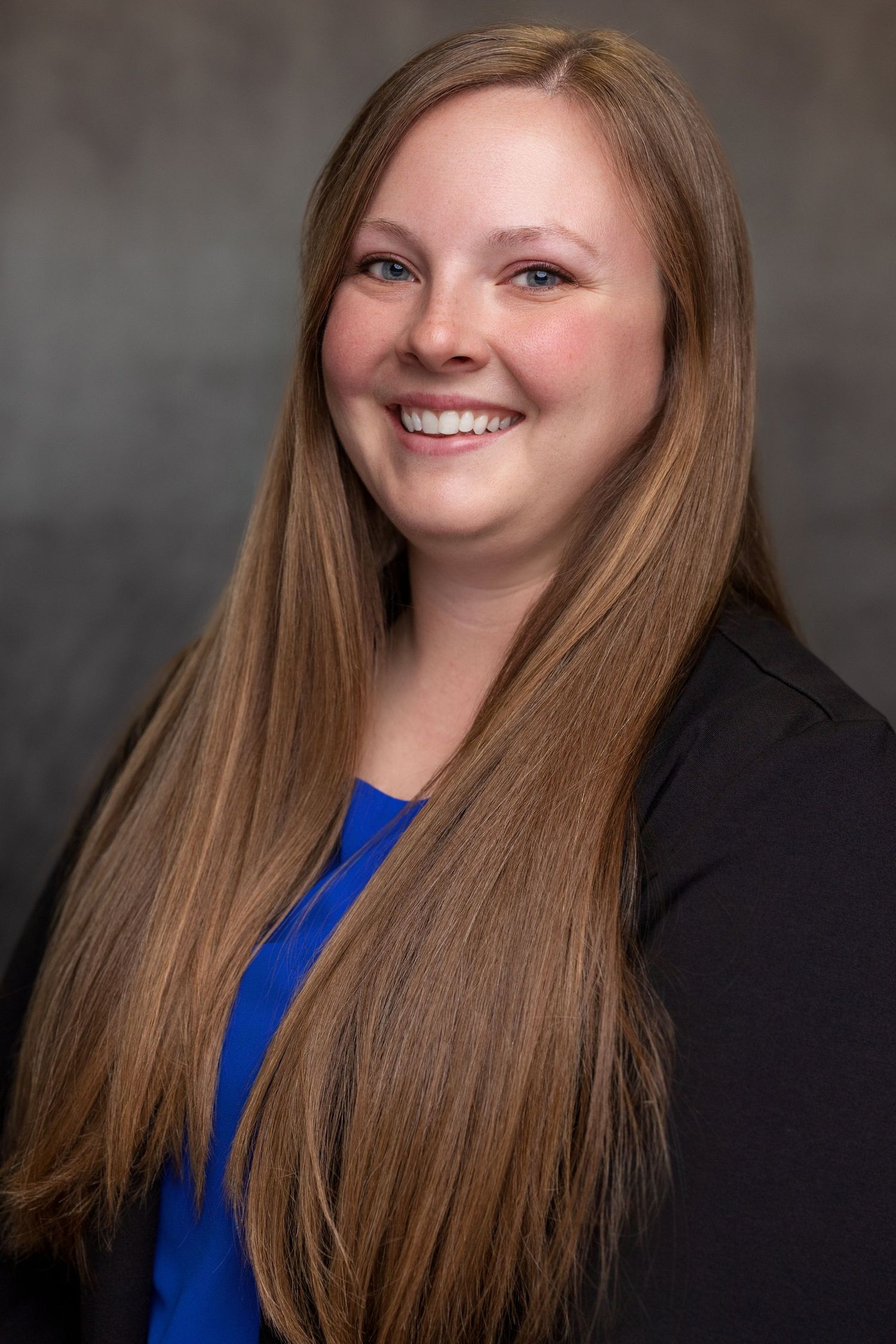 Series of corporate portraits featuring person in blue top and dark blazer with long hair.