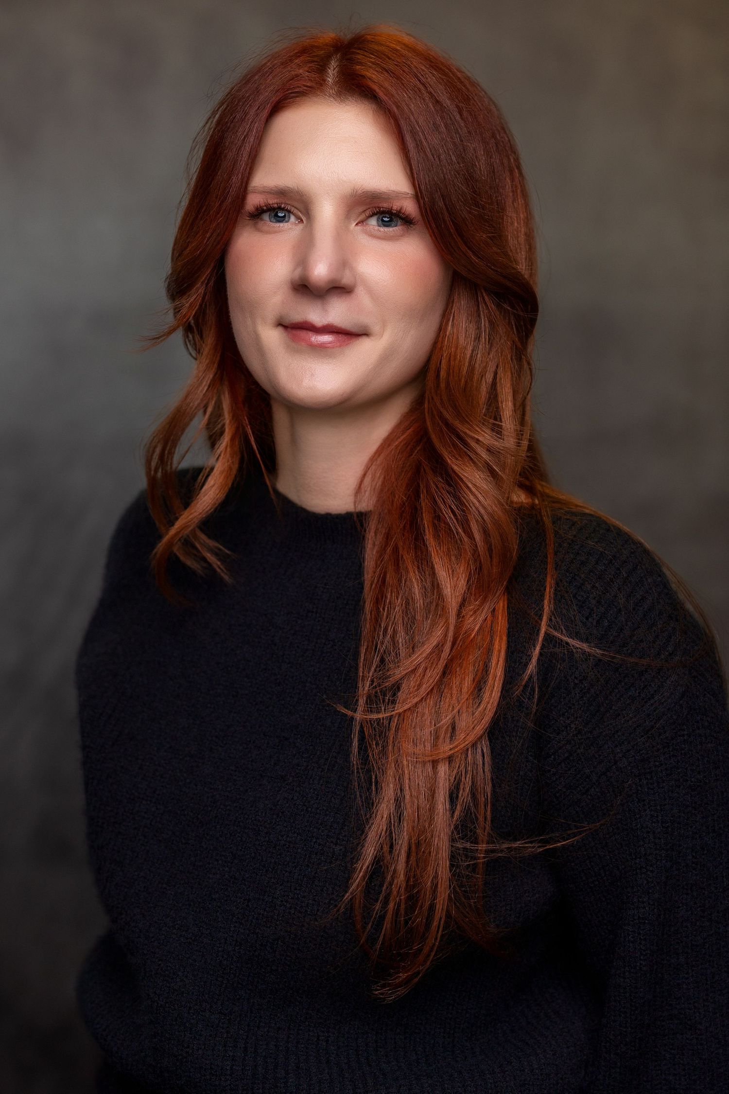 Professional headshot series showing person with red hair wearing black sweater against dark background.
