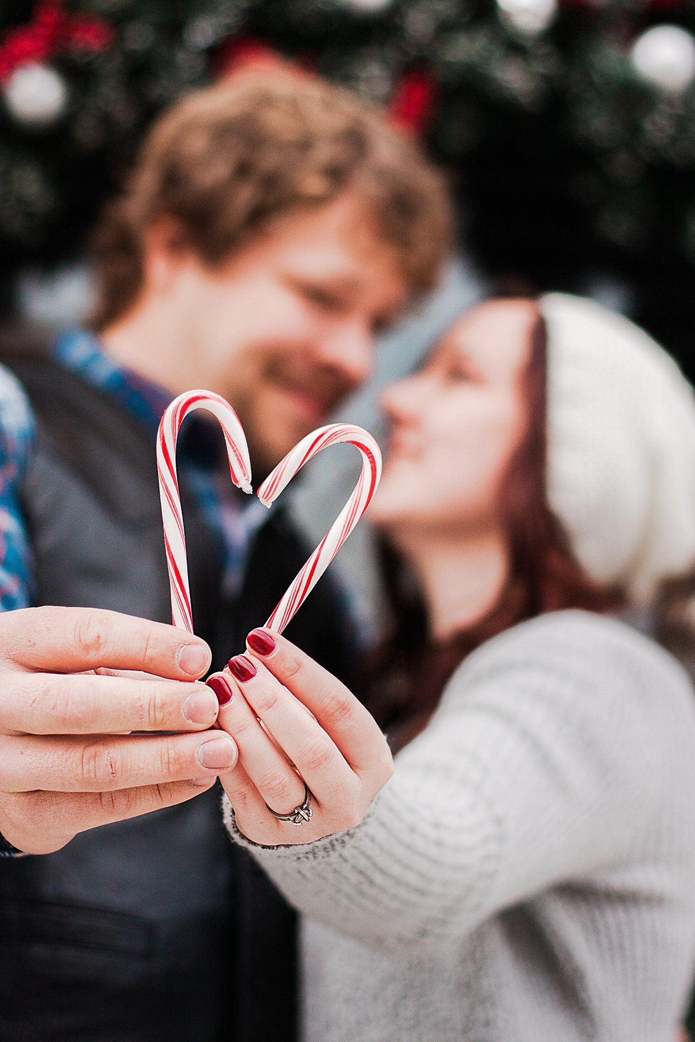 Couple holds up 2 candycanes to form the shape of a heart