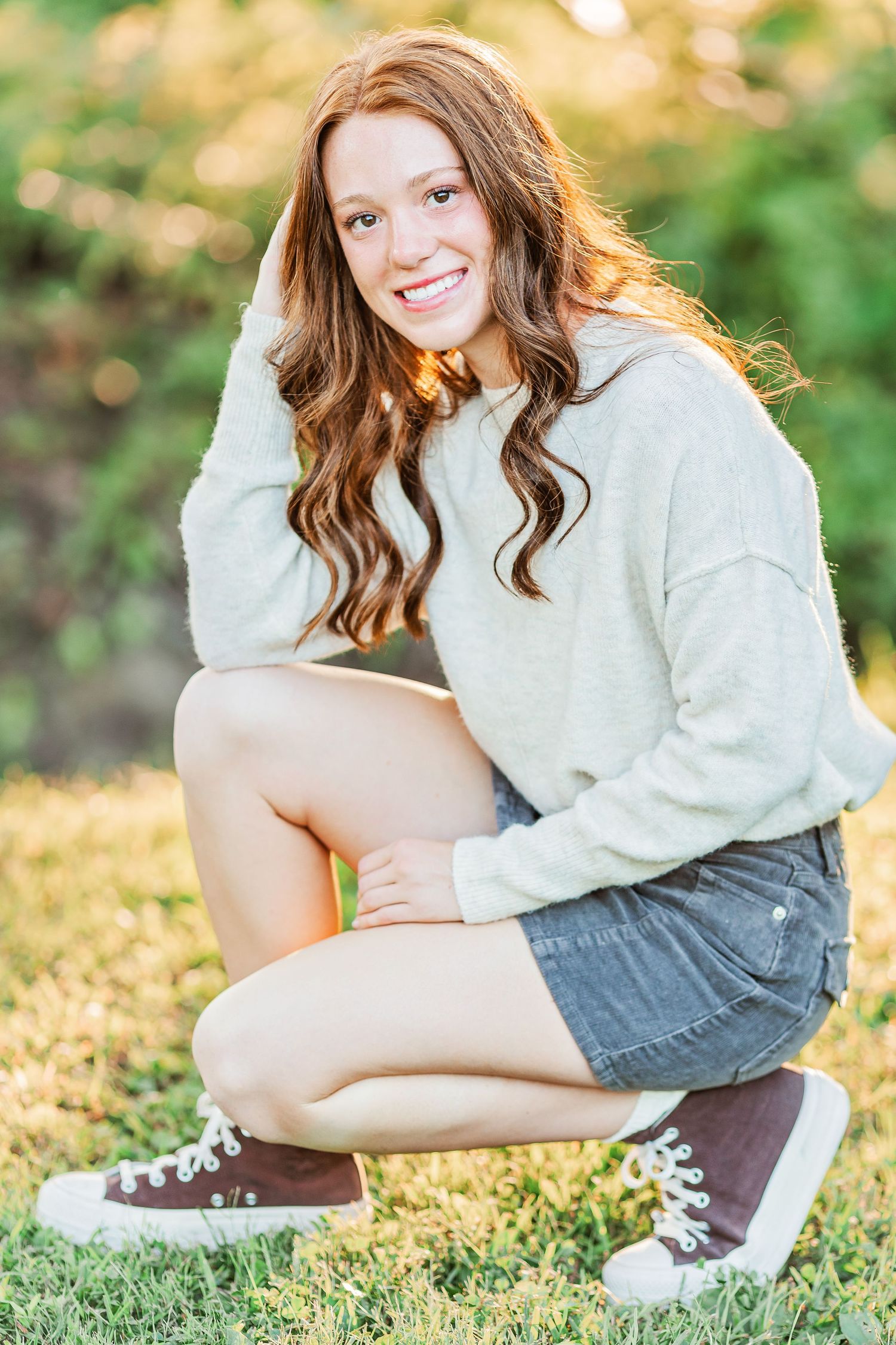 A casual outdoor portrait featuring a cozy sweater and denim shorts on a sunny autumn day.