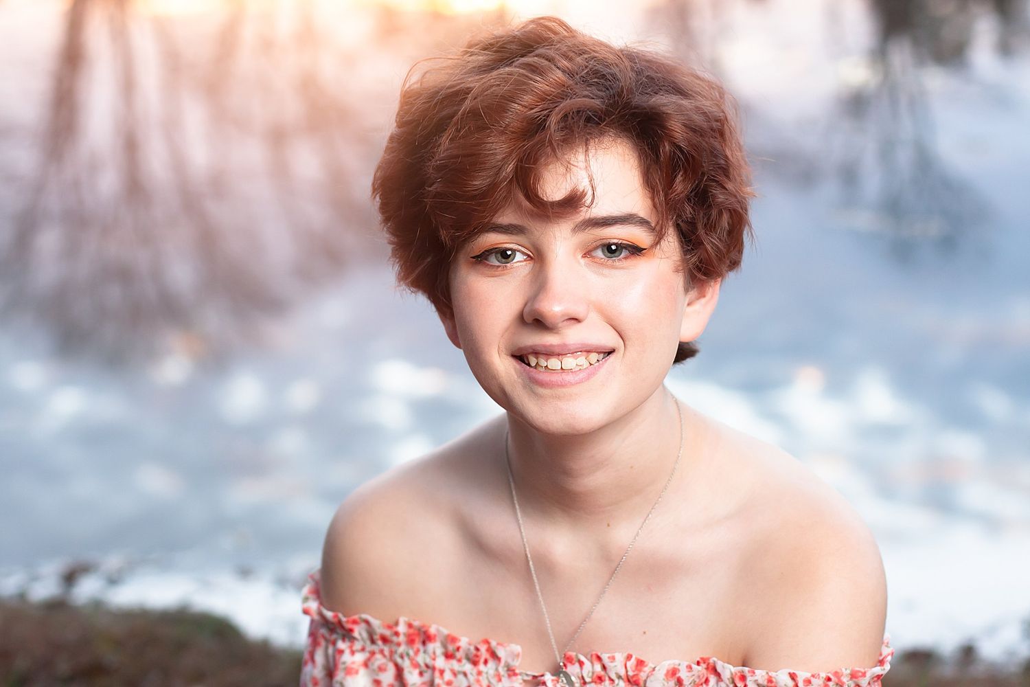 Portrait of someone in off-shoulder dress against snowy winter background.