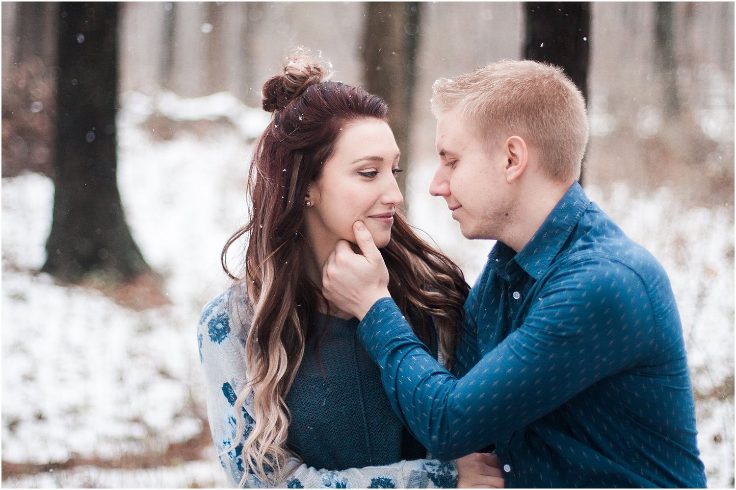 An intimate winter portrait showing a tender moment between a couple in blue outfits.