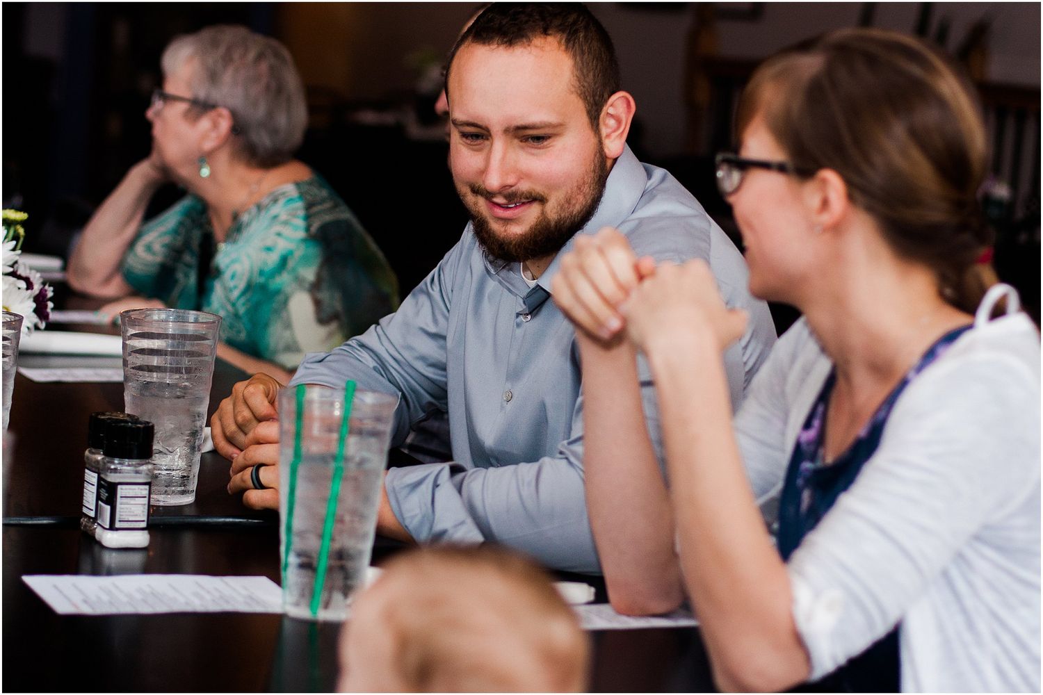 People engaged in conversation around a table during a social gathering.