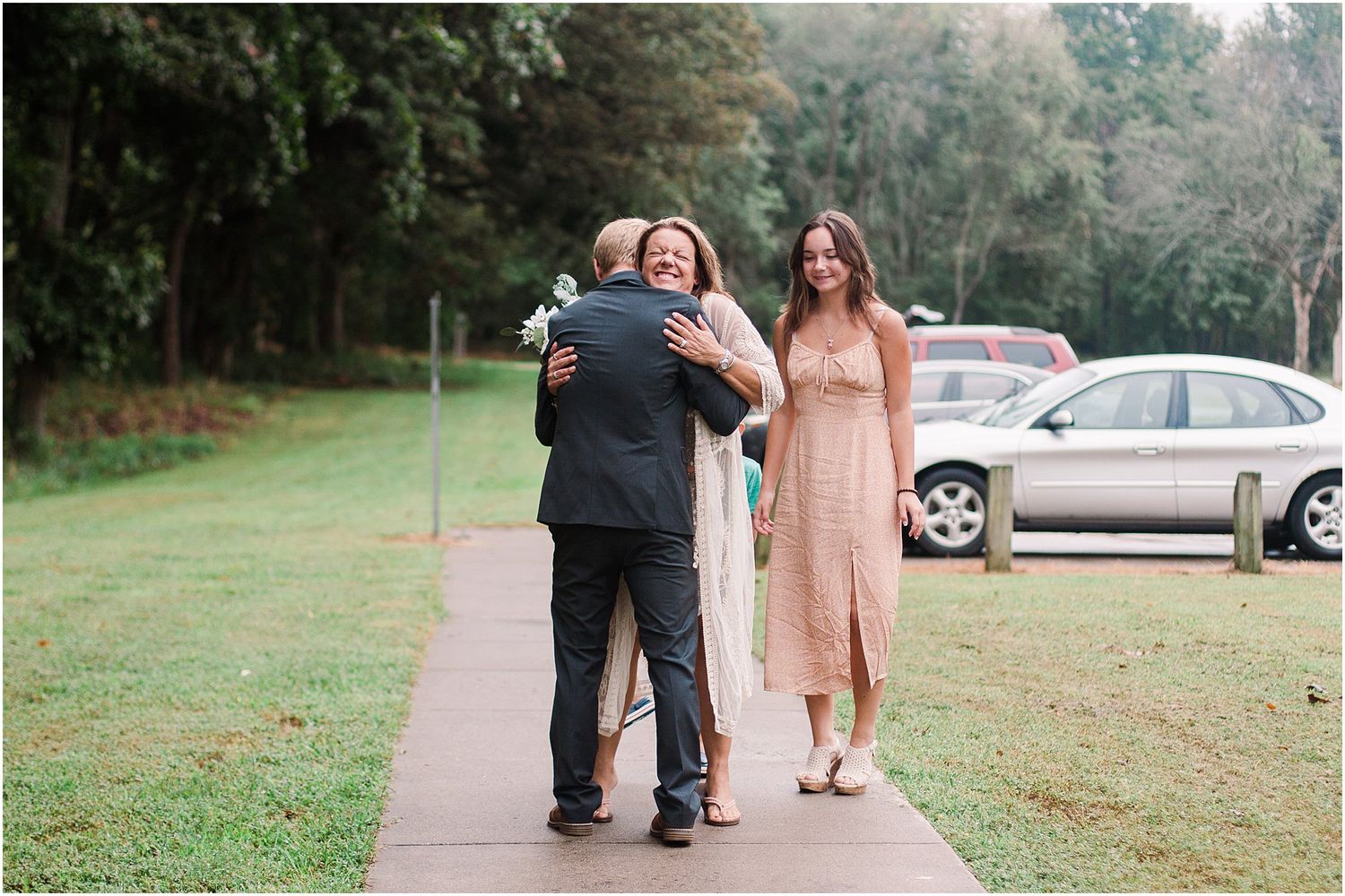 Emotional moment captured during wedding celebration on outdoor pathway.