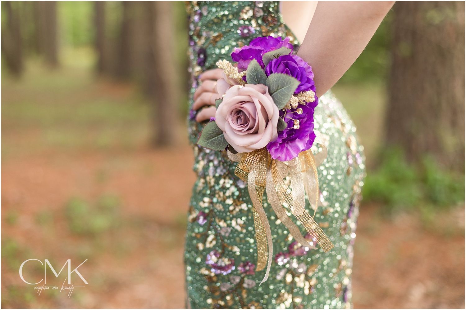Detailed view of an elegant wrist corsage with lavender rose and purple flowers against sequined fabric.