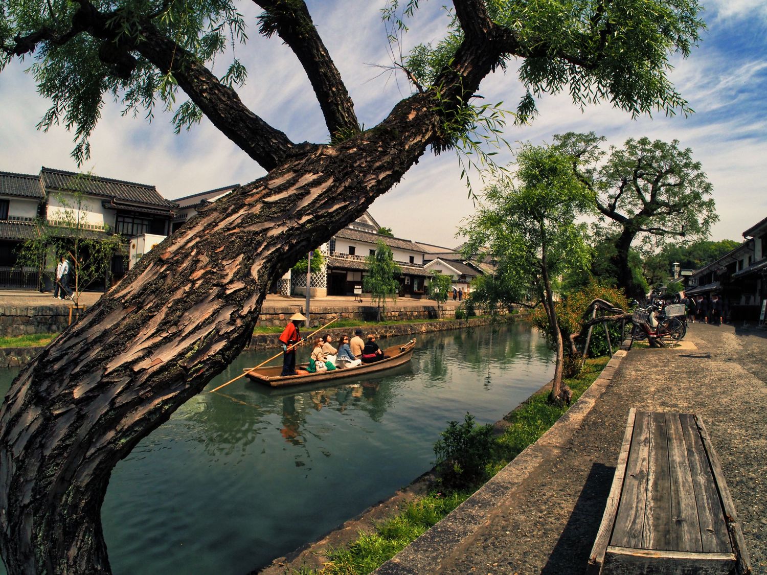 Photograph of a canal boat with passengers from the Kurashikik Bikan District in Japan.  This was a zone for Japanese warrior knights.