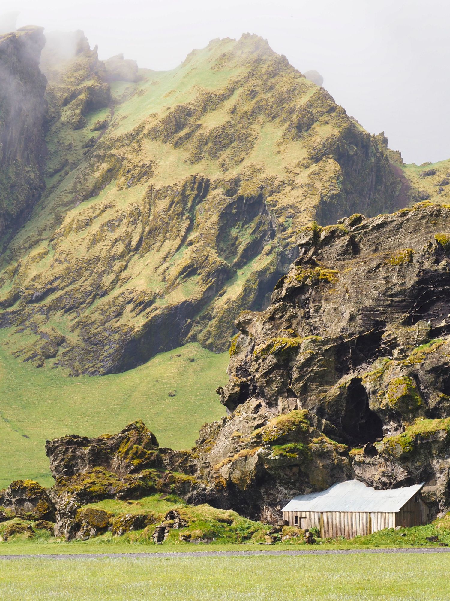 Photograph of mountains rising from a field or plain on the south coast of Iceland.