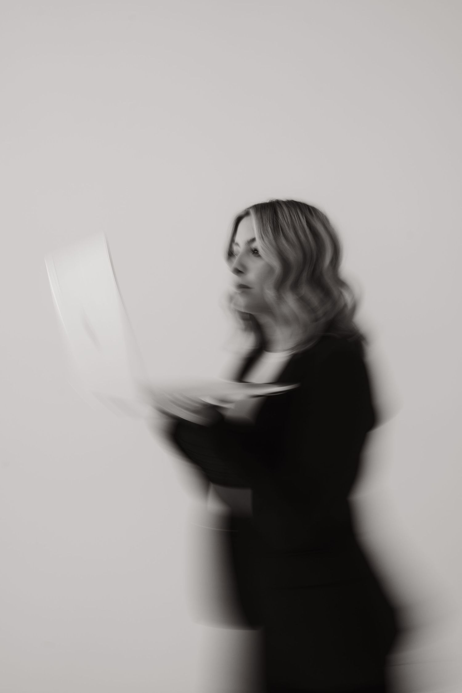 Artistic black and white motion blur shots of person with papers.
