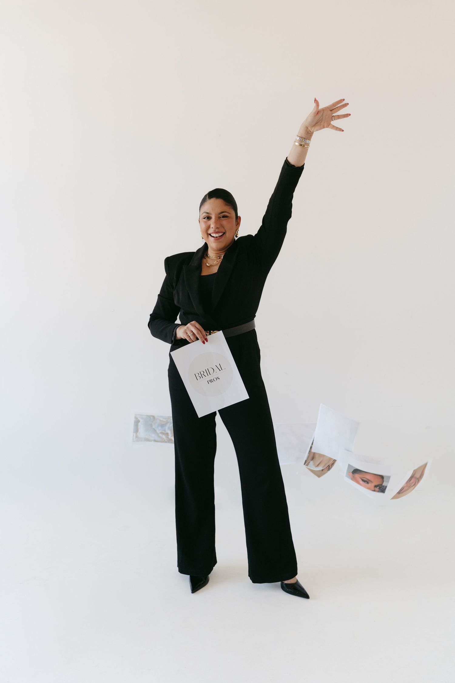 Energetic poses showing person in black outfit tossing papers in studio setting.