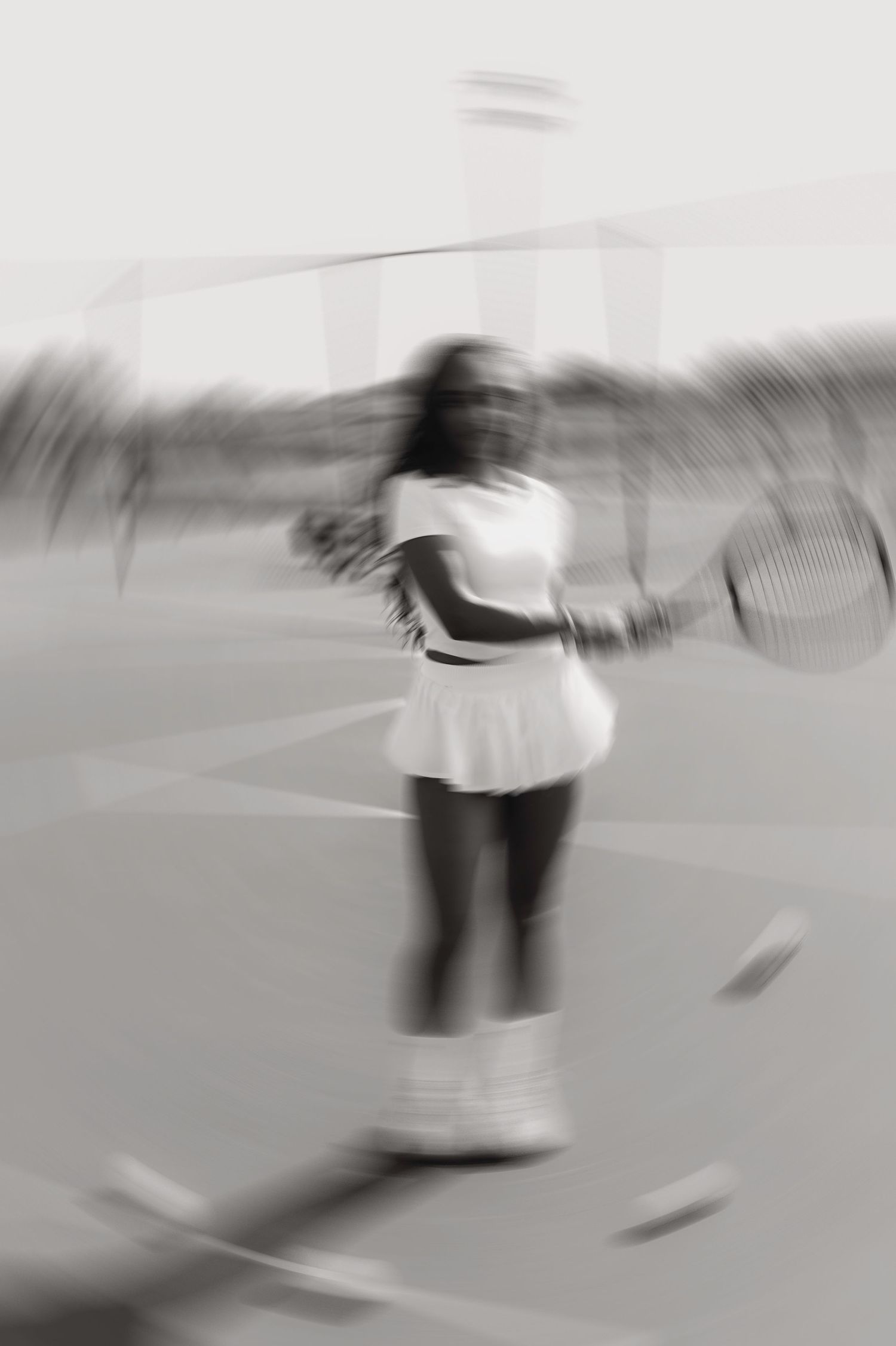 Motion-blurred black and white photo of tennis player on court.