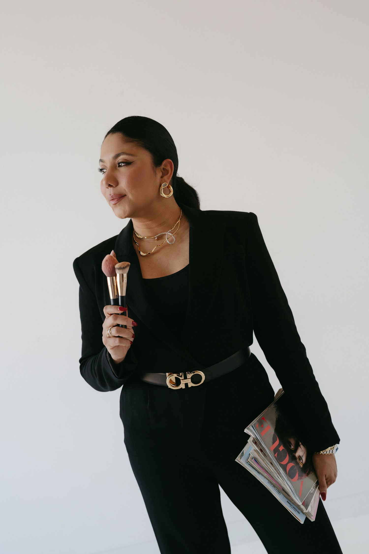 Professional in black business attire holding papers and phone in dynamic poses.