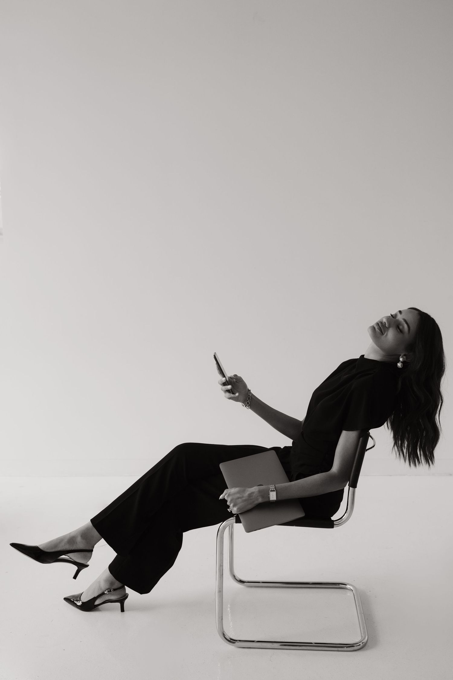 Artistic black and white photo series showing person reclining dramatically in modern chair.