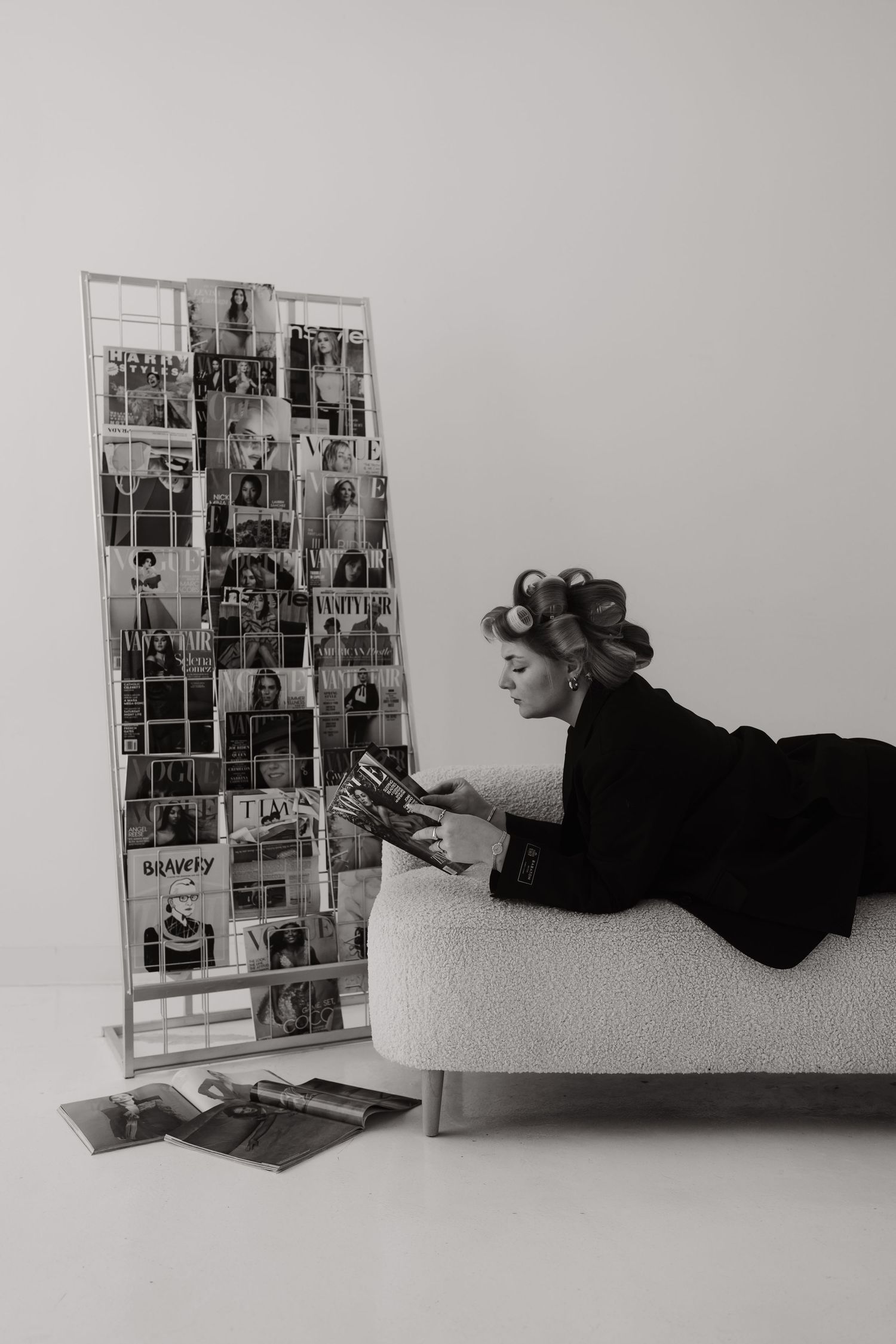 Black and white photos of person lying down viewing photo collage display.
