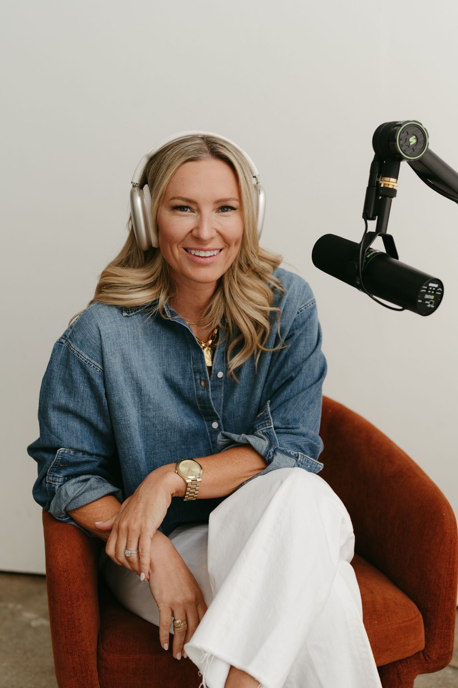 Professional headshots of person sitting in brown armchair with recording equipment.